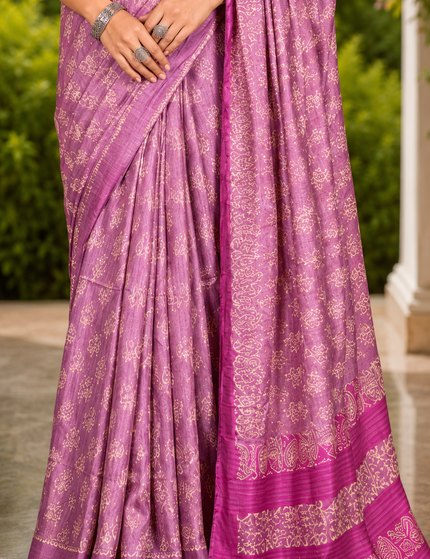 Close-up of a mauve-lavender Tussar silk cotton saree showing delicate white Batik floral print, pleats, magenta border, and patterned bands.