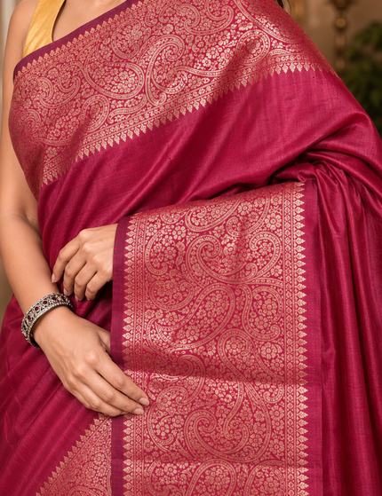 Close-up of rose-gold zari paisley border on magenta handwoven cotton saree