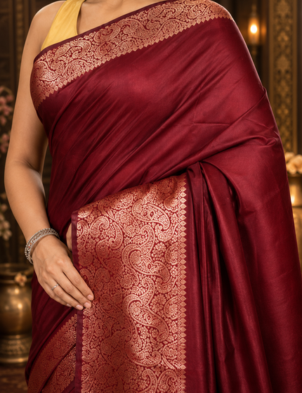 Close-up of copper-rose zari paisley border on maroon handwoven cotton saree