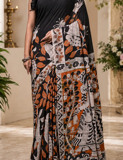 Detail view of black and rust Kalamkari digital print cotton saree pleats, pallu and printed border