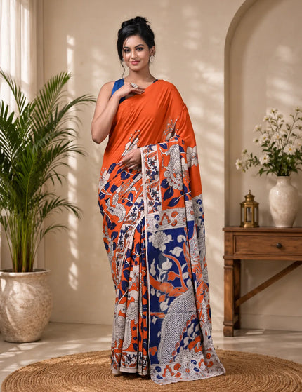 Model wearing an orange and navy Kalamkari digital print cotton saree, full-length view showing figurative motifs, floral patterns and decorative border.