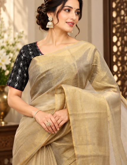 Close-up of ivory Mull cotton saree draped over shoulder with golden border